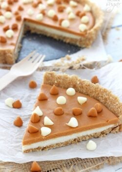 A big slice of White Chocolate Butterscotch Tart on white paper and a fork