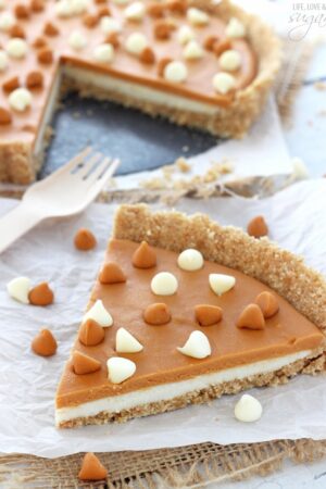 A big slice of White Chocolate Butterscotch Tart on white paper and a fork