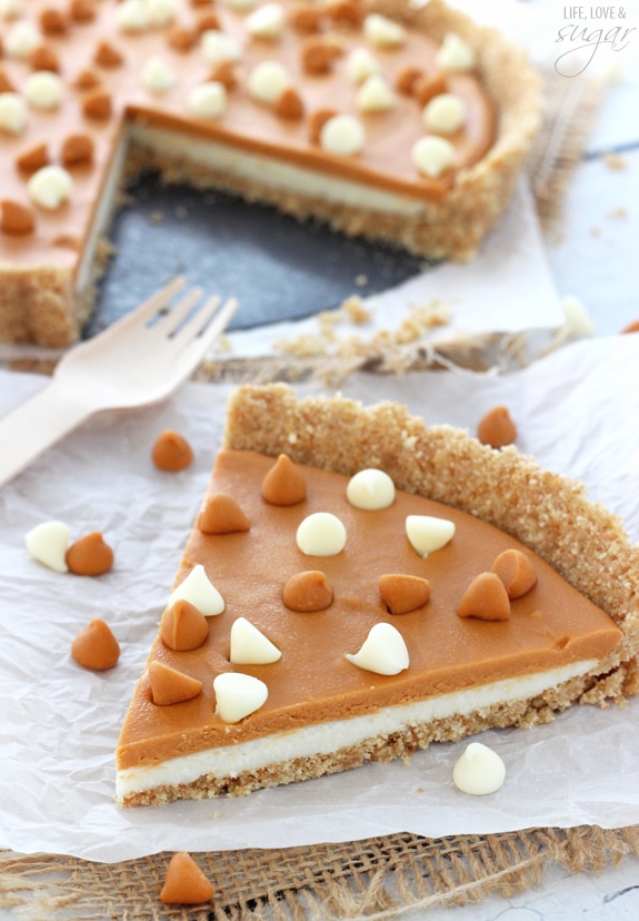 A slice of homemade tart on white paper surrounded by white chocolate and butterscotch chips