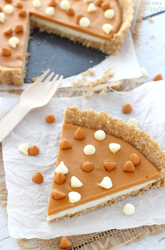A big slice of White Chocolate Butterscotch Tart on white paper and a fork