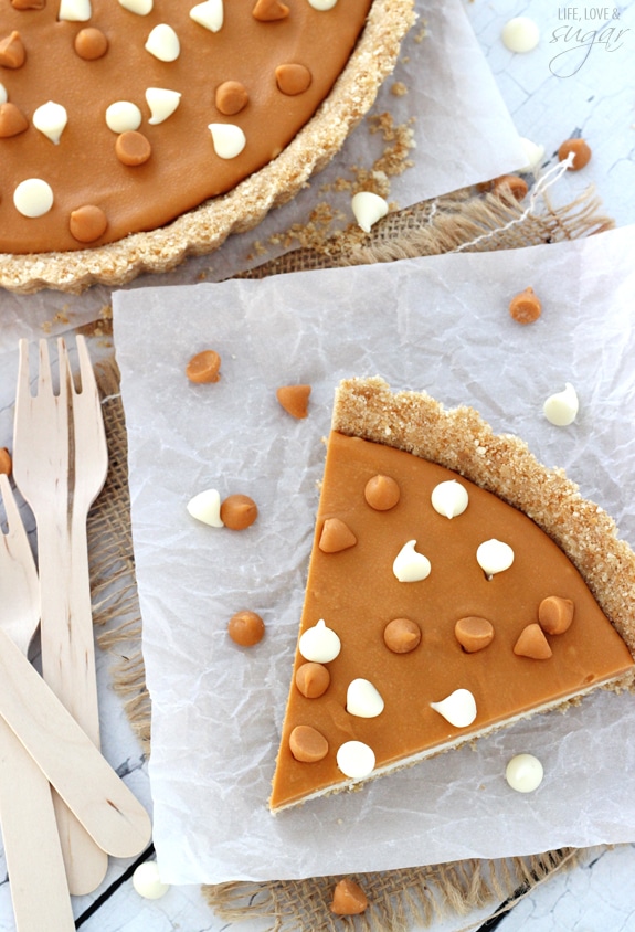 A slice of tart on white paper surrounded by white chocolate chips and butterscotch chips