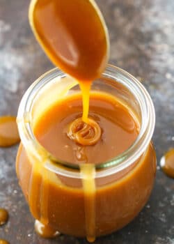 Drizzling caramel sauce into a jar full of it.