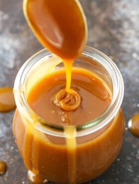 Drizzling caramel sauce into a jar full of it.