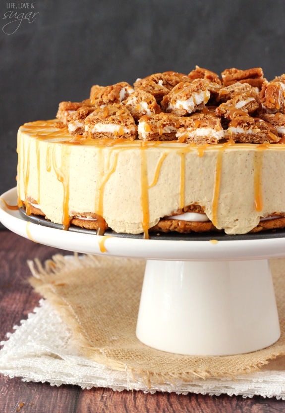 Side view of No Bake Oatmeal Cream Pie Cheesecake on a white cake stand