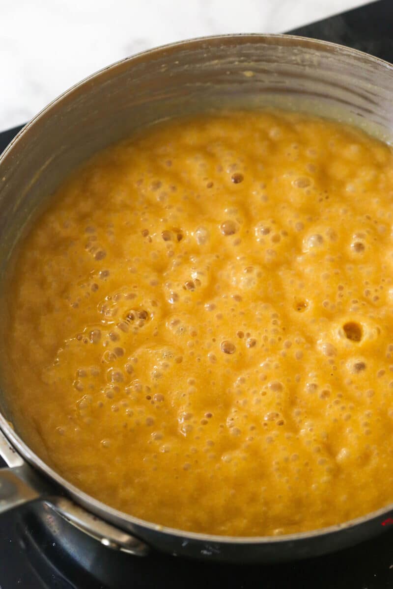 stage two and three of the caramel making process with the caramel boiling in a saucepan