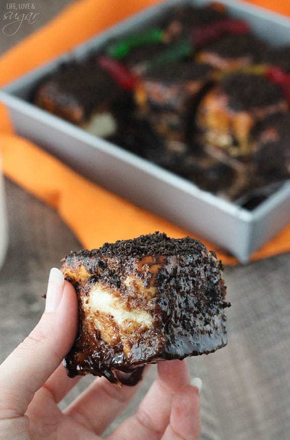 A hand holding a gooey chocolate Sticky Bun