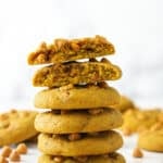 stack of pumpkin butterscotch chip cookies with one broken in half on top