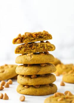 stack of pumpkin butterscotch chip cookies with one broken in half on top