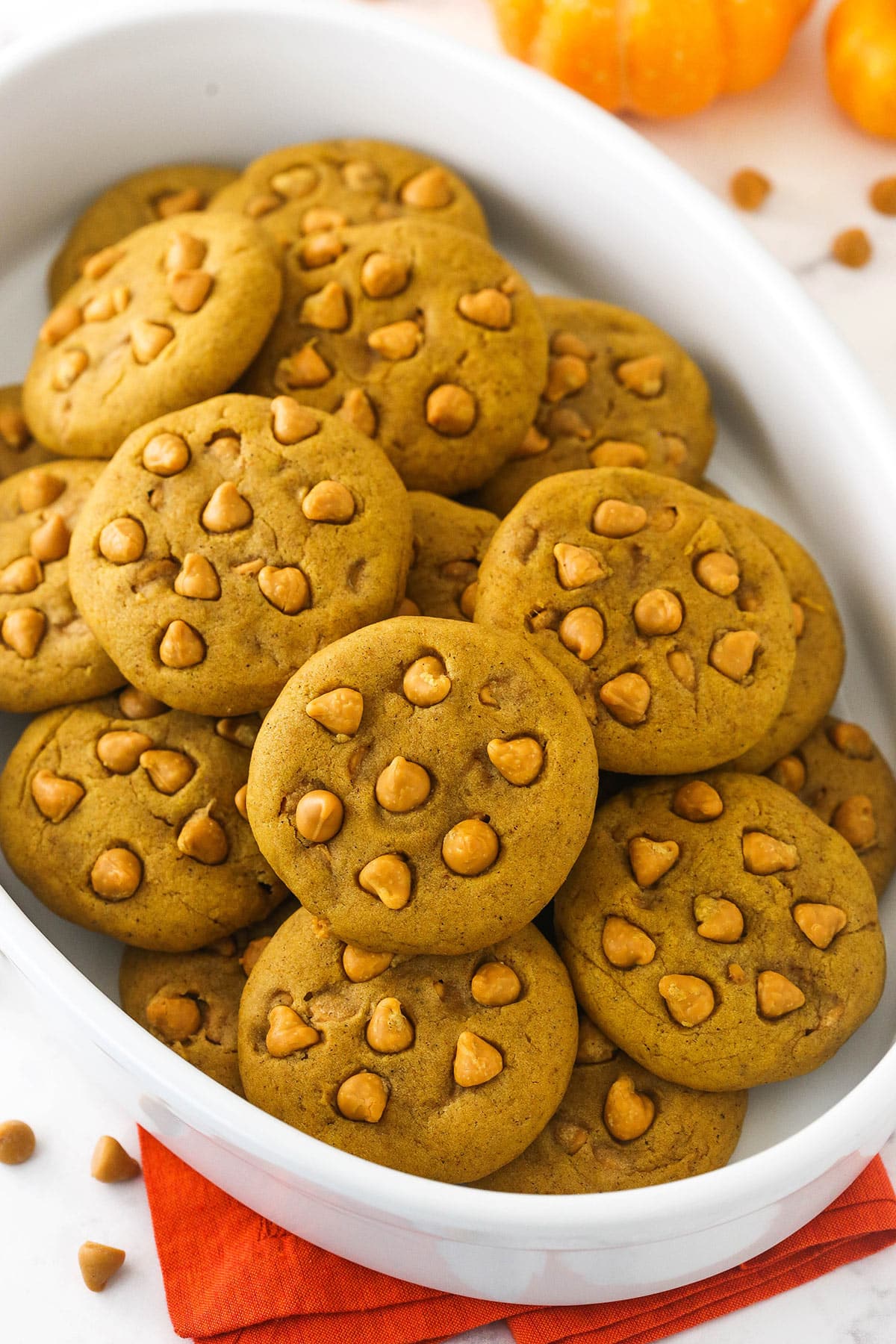 pumpkin cookies in a white dish on an orange napkin