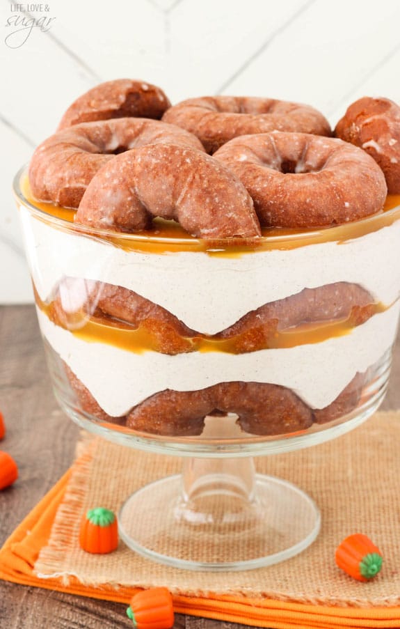 Pumpkin Spice Donut Cheesecake Trifle with layers of pumpkin spice donuts, no bake cheesecake and caramel sauce in a trifle bowl