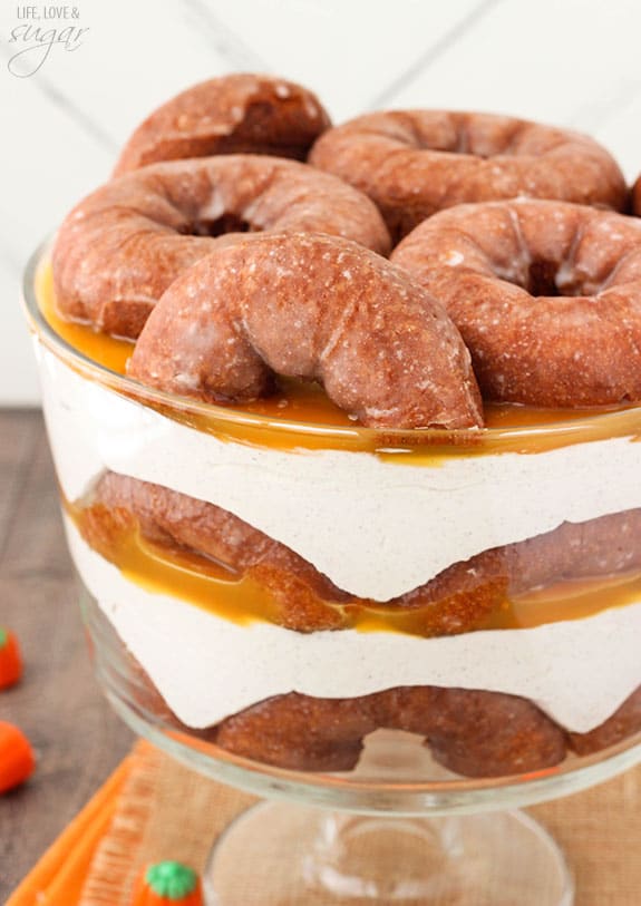 Pumpkin Spice Donut Cheesecake Trifle with layers of pumpkin spice donuts, no bake cheesecake and caramel sauce in a trifle bowl