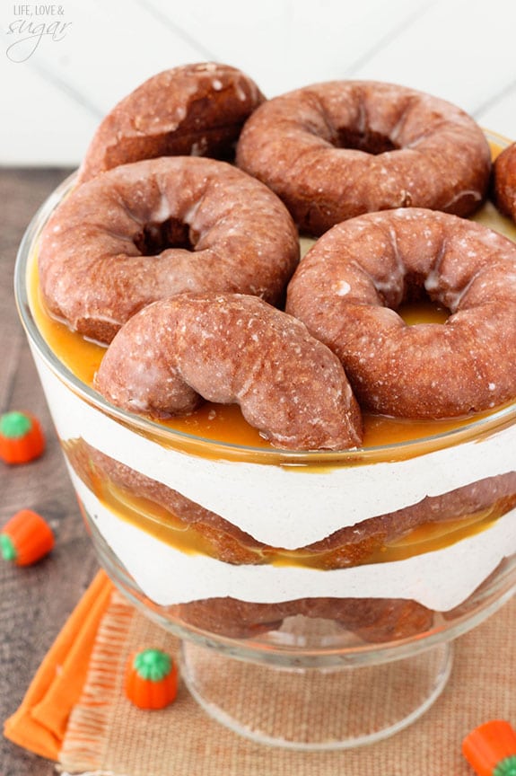 Overhead view of Pumpkin Spice Donut Cheesecake Trifle with layers of pumpkin spice donuts, no bake cheesecake and caramel sauce in a trifle bowl