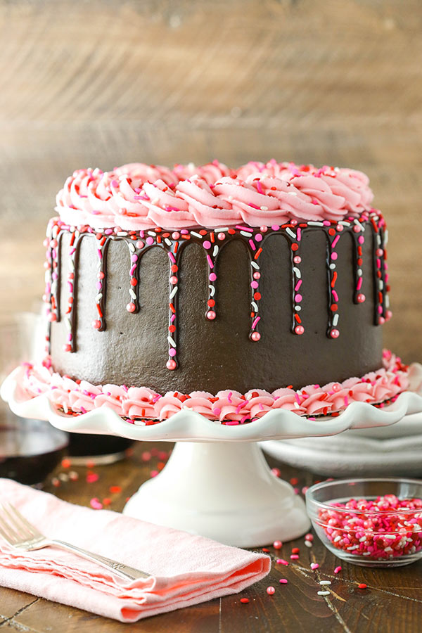 Chocolate ganache drizzled down the side of a chocolate cake with pink buttercream.