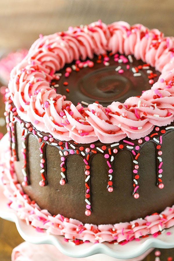 Chocolate cake with chocolate ganache and pink frosting.