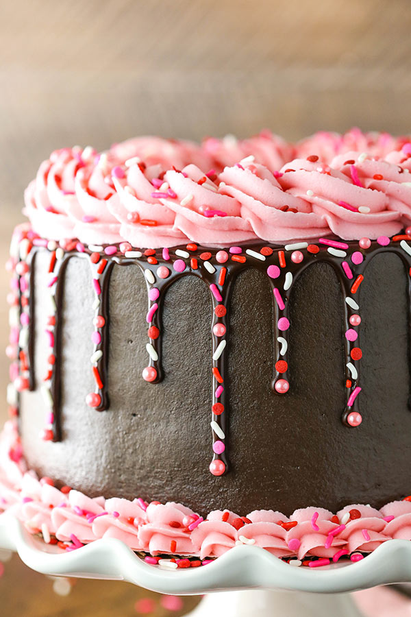 Side view of Frosted chocolate cake with pink frosting and sprinkles