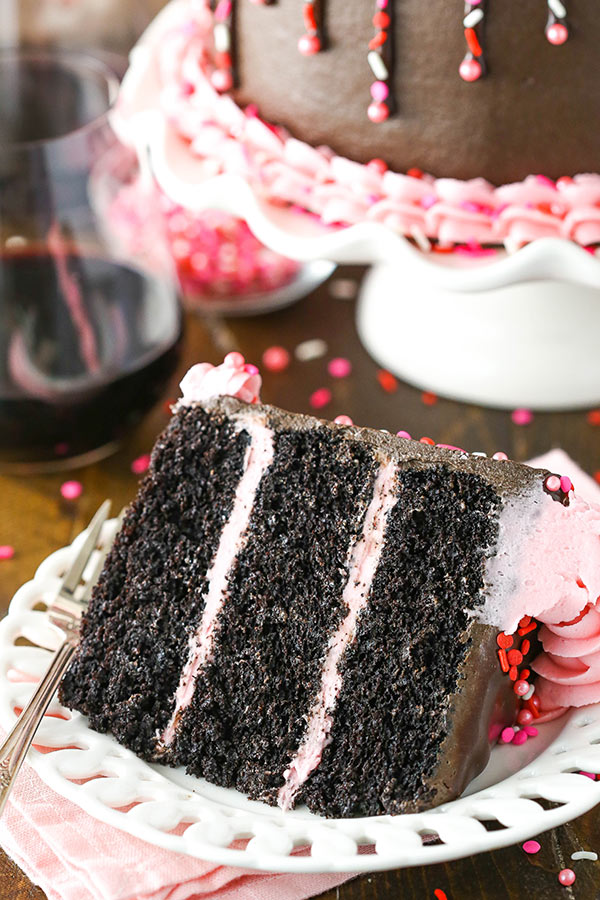 A slice of moist chocolate cake on a white plate.