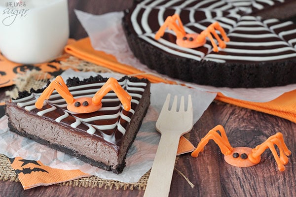 Spiderweb Chocolate Tart slice on a napkin topped with an orange candy spider