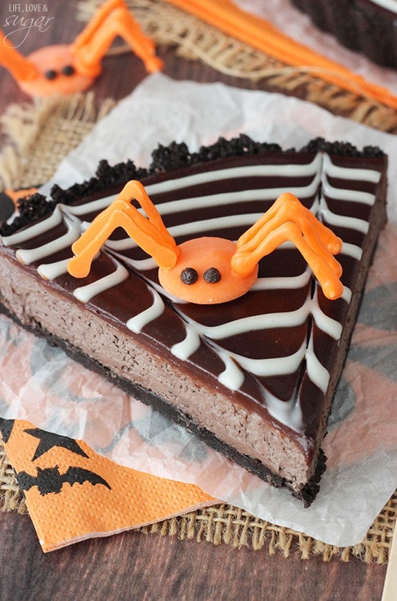 Spiderweb Chocolate Tart slice on a napkin topped with an orange candy spider