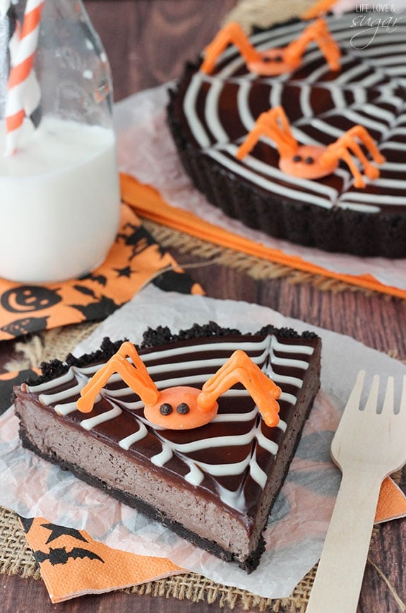 Spiderweb Chocolate Tart slice on a napkin topped with an orange candy spider