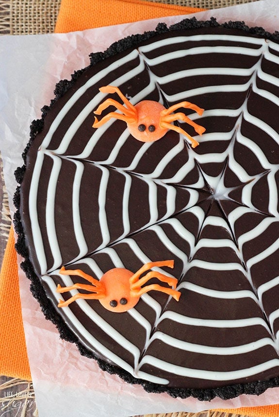 Overhead view of Spiderweb Chocolate Tart topped with orange candy spiders