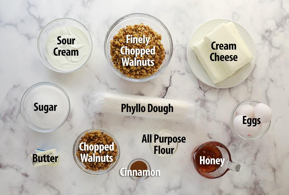 With a phyllo dough crust, creamy cheesecake filling, and honey walnut topping, Baklava Cheesecake is a fun twist on the traditional dessert. Overhead view of ingredients needed to make baklava cheesecake