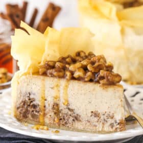 A slice of baklava cheesecake on a white plate