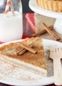 Milk Tart slice on white plate with cinnamon sticks close up