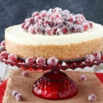 No Bake Sparkling Cranberry Orange Cheesecake on red stand close up