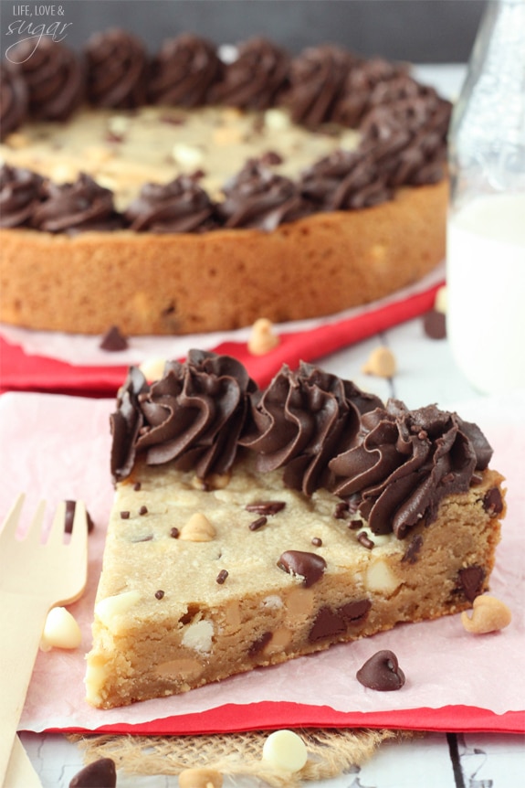 Triple Chocolate Chip Cookie Cake slice on a napkin in front of the whole cake
