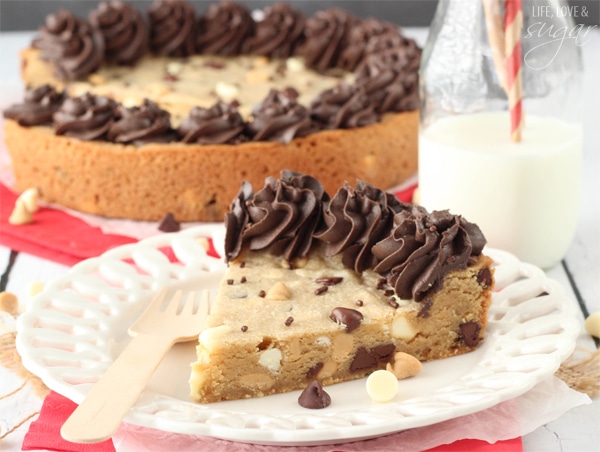 Triple Chocolate Chip Cookie Cake slice on a white plate in front of the whole cake