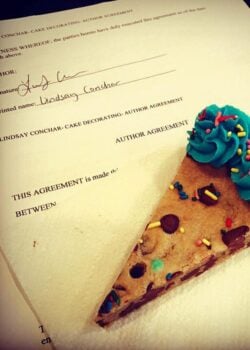 A slice of cookie cake and my authors contract for my new cookbook!