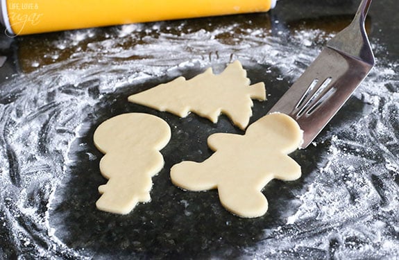 Shaped sugar cookie dough on floured counter