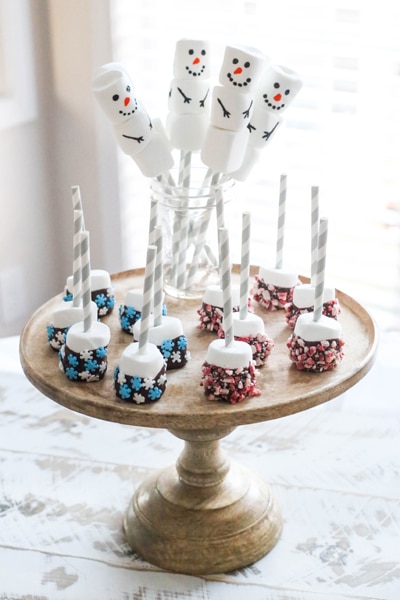 snowman marshmallows and dipped marshmallows on wooden cake stand