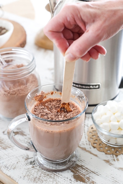 stirring hot chocolate in a mug with wooden spoon