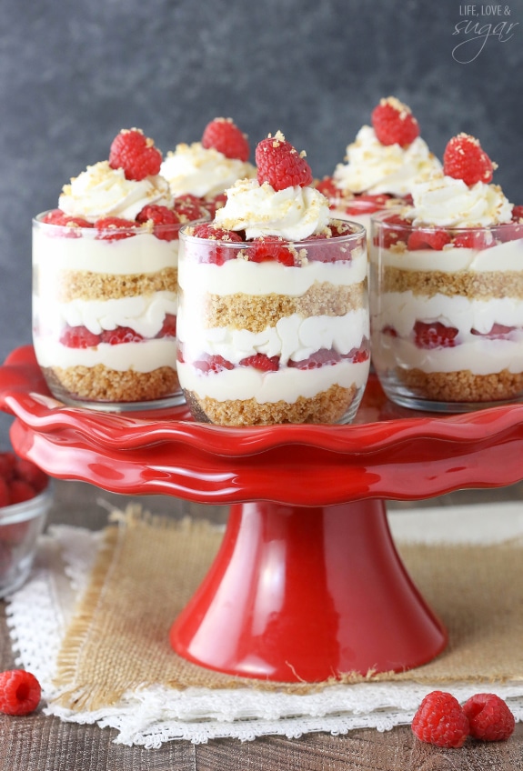 Raspberry Amaretto Cheesecake Trifles on a red cake stand