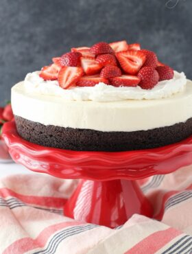 Strawberry Brownie Cheesecake on red stand close up