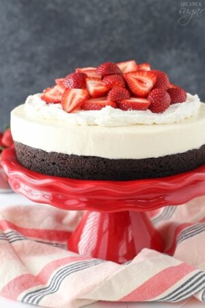 Strawberry Brownie Cheesecake on red stand close up