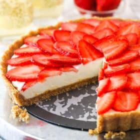 strawberry champagne tart on silver platter with slice cut out