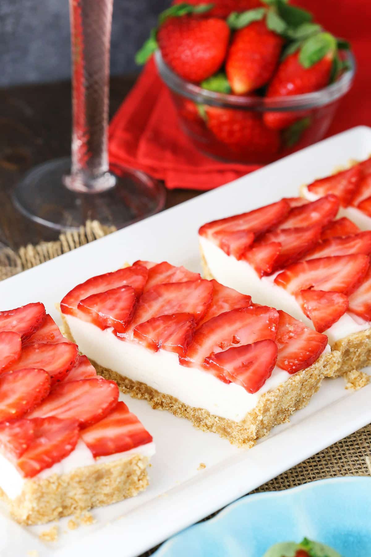 Slices of strawberry champagne tart lined up on a long dessert platter.