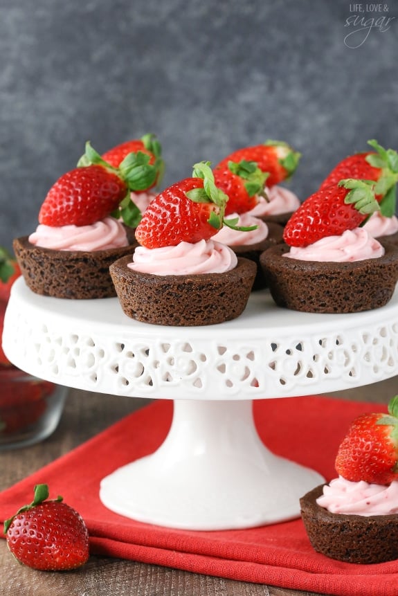 Strawberry Cheesecake Chocolate Cookie Cups on a white cake stand