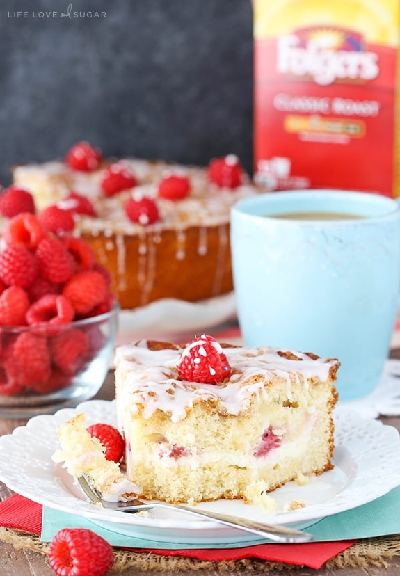 Raspberry Cream Cheese Coffee Cake slice with bite on fork and coffee in the background