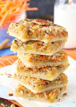 Carrot Cake Shortbread Bars stacked on a napkin with a bite taken out of the top one