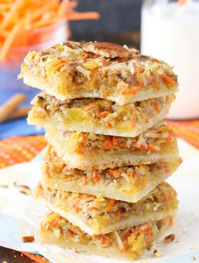 Carrot Cake Shortbread Bars stacked on a napkin with a bite taken out of the top one