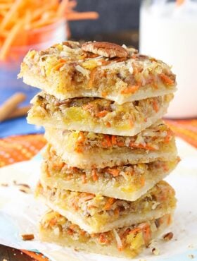 Carrot Cake Shortbread Bars stacked on a napkin with a bite taken out of the top one