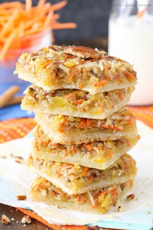 Carrot Cake Shortbread Bars stacked on a napkin with a bite taken out of the top one