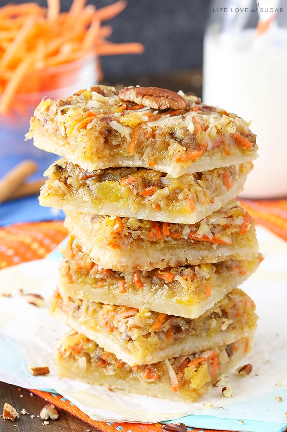 Carrot Cake Shortbread Bars stacked on a napkin with a bite taken out of the top one