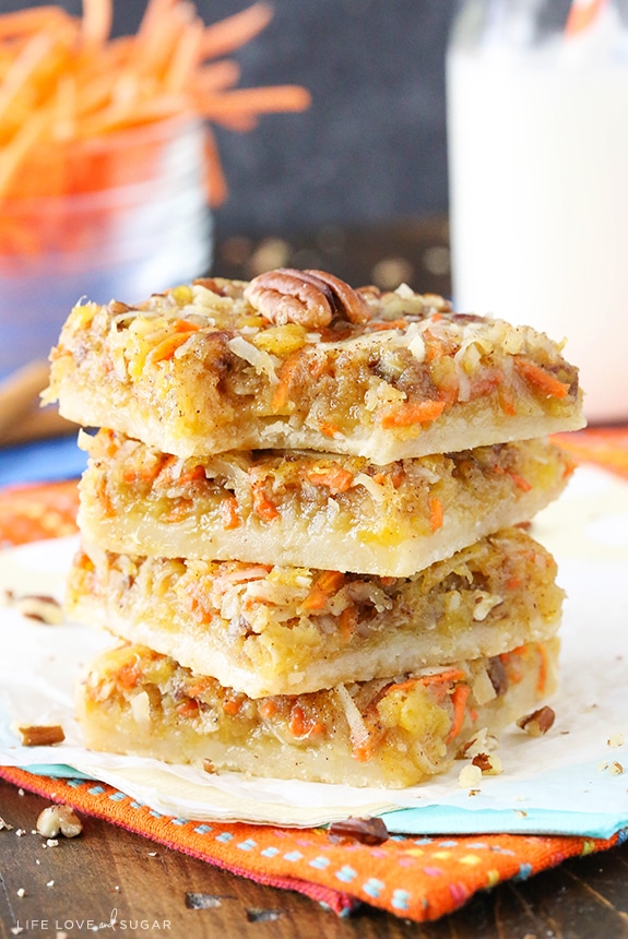 Carrot Cake Shortbread Bars stacked on a napkin with a bite out of one
