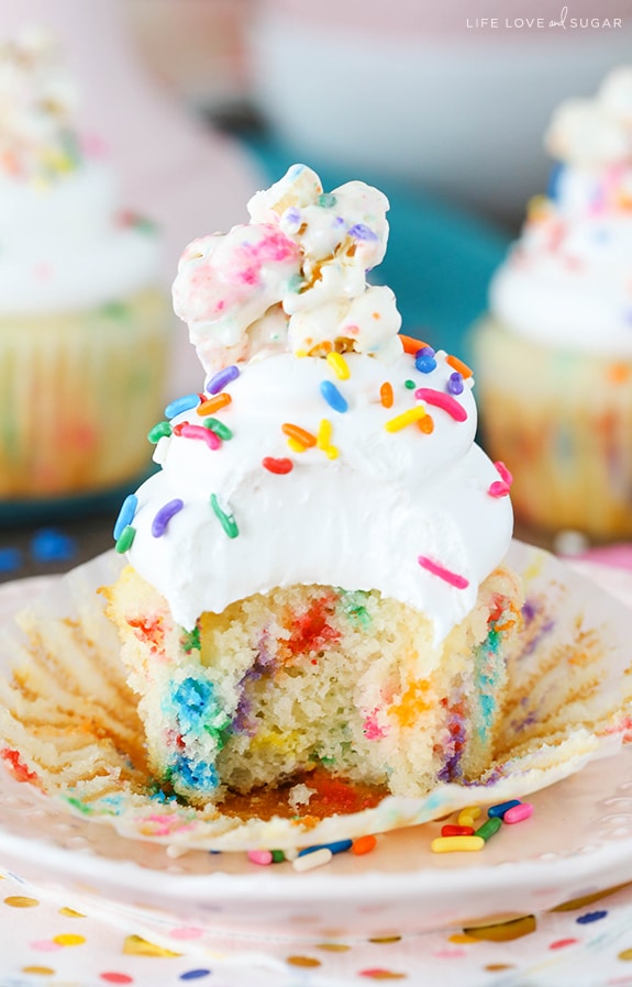 Funfetti Popcorn Marshmallow Treat Cupcake with a bite taken out on a plate