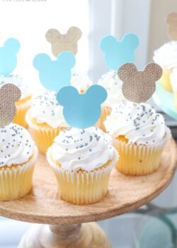 Mickey Mouse Themed Cupcakes with White Frosting and Sprinkles on a Cake Stand