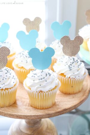 Mickey Mouse Themed Cupcakes with White Frosting and Sprinkles on a Cake Stand